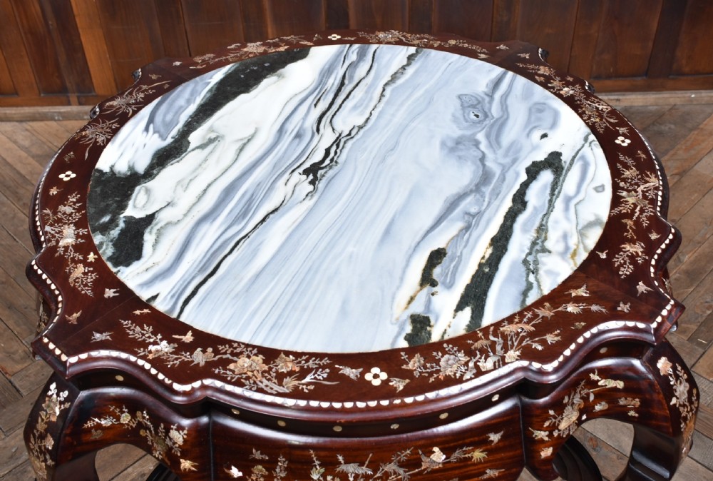 A circular dark hardwood centre table featuring intricate mother-of-pearl floral inlays, carved cabriole legs, and a grey and white variegated marble inset top. View V