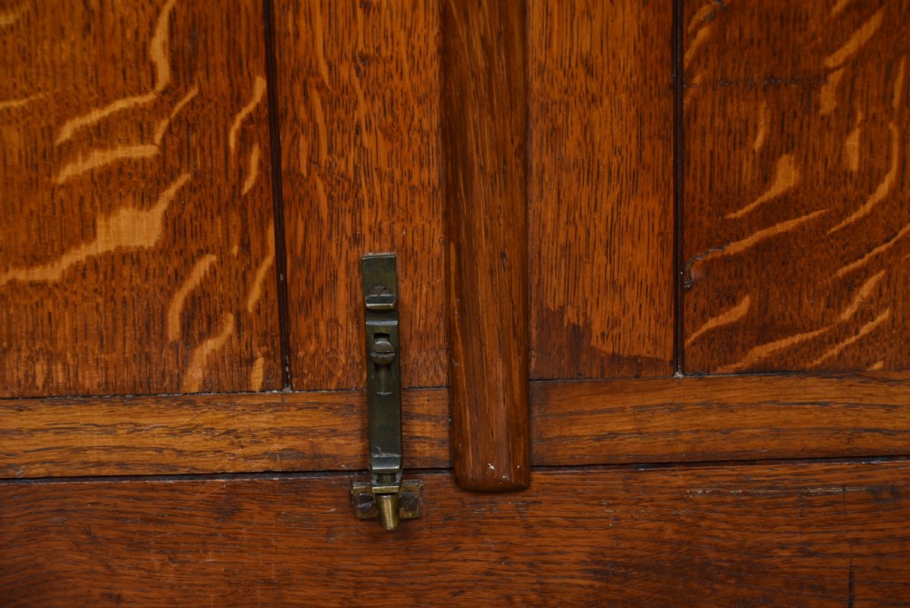 A Victorian oak counter-top display cabinet featuring carved border trim, interior wooden shelves, a glazed front, and a top brass keyhole. View XIII