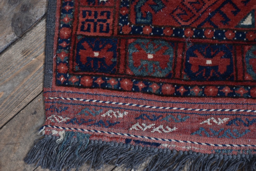A handwoven red wool rug featuring double arched niche motifs, geometric border patterns, dark navy details, and fringe ends. View VIII