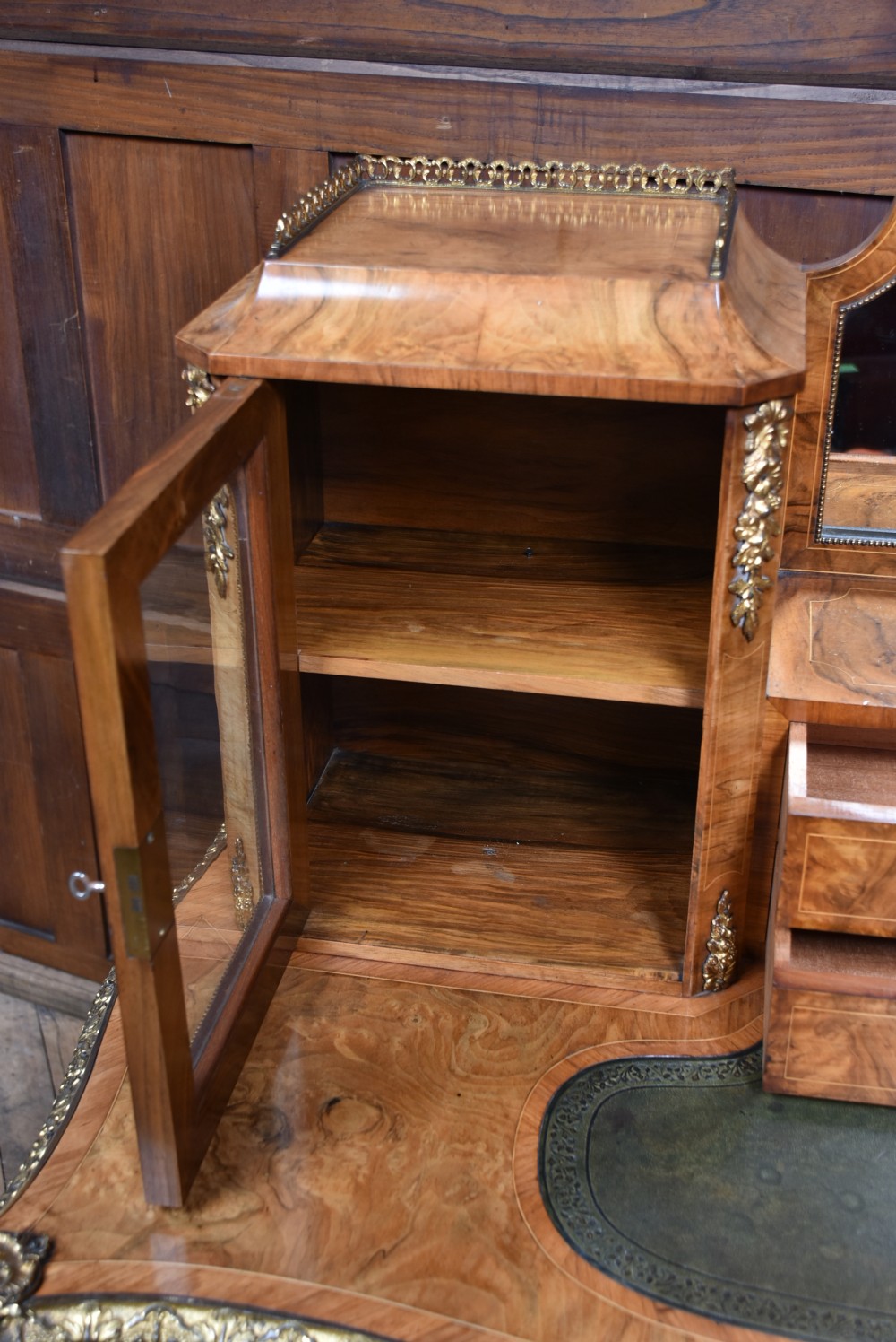 Victorian burr walnut writing desk featuring cabriole legs, brass mounts, an inset leather writing top, and an upper superstructure with glazed side cabinets and a central mirror. View XII