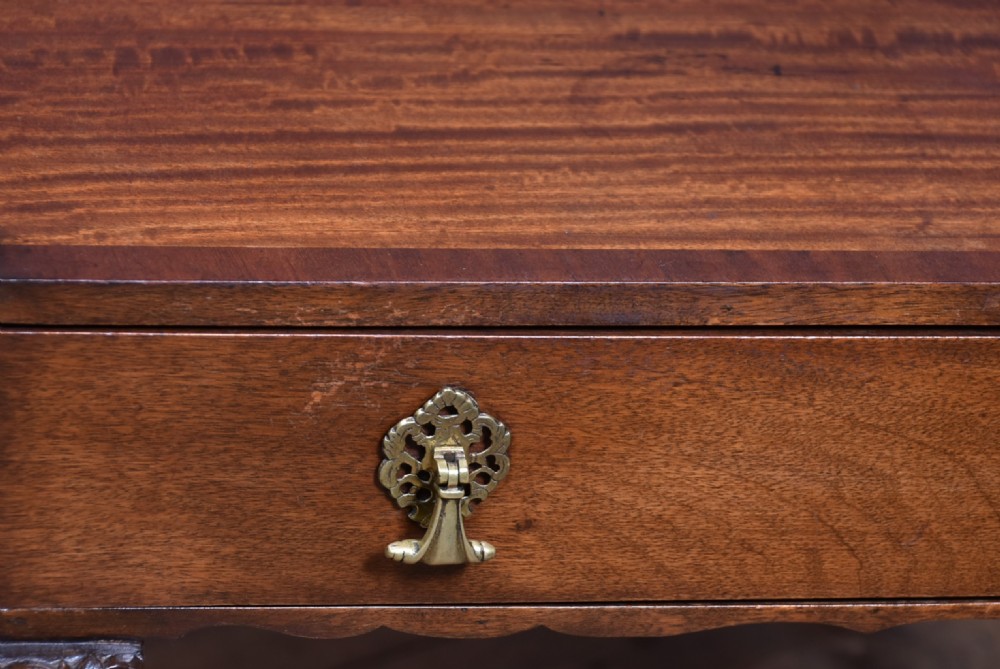 An Edwardian mahogany side table featuring a raised gallery top, a single drawer with brass drop handles, and carved cabriole legs. View III