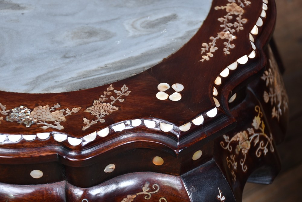 A pair of low Chinese dark hardwood plant stands featuring circular inset marble tops, Mother-of-Pearl floral inlay along the scalloped aprons, and carved cabriole legs. View VII