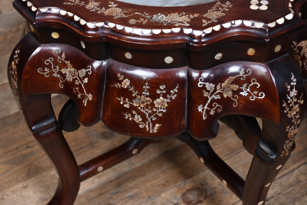 A pair of low Chinese dark hardwood plant stands featuring circular inset marble tops, Mother-of-Pearl floral inlay along the scalloped aprons, and carved cabriole legs. View IX
