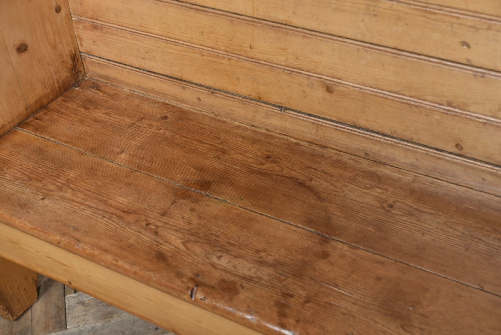 A high-backed antique pine tavern bench featuring horizontal panelled construction and shaped side supports. View IX