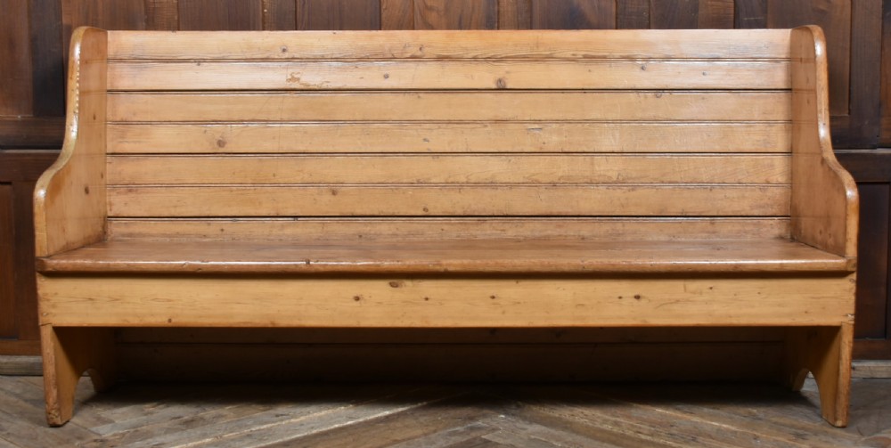 A high-backed antique pine tavern bench featuring horizontal panelled construction and shaped side supports. View X