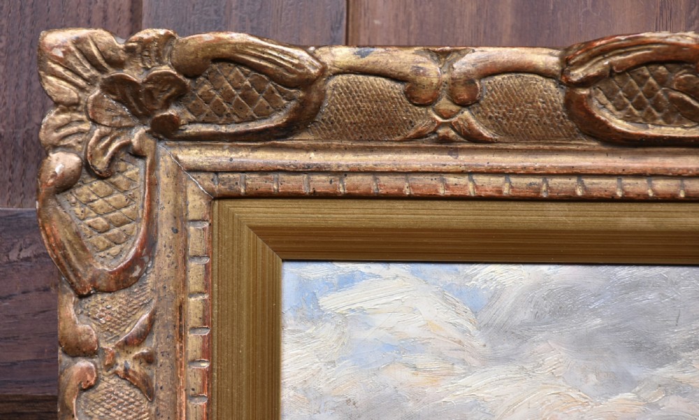 An impressionist oil painting depicting figures casting off in a rowing boat from a rocky shore, housed in an ornate carved gold gilt frame. View V