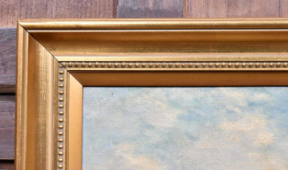 An oil painting set within a moulded gilt frame depicting farm workers and heavy horses gathering hay stooks in an open field under a cloudy sky. View VI