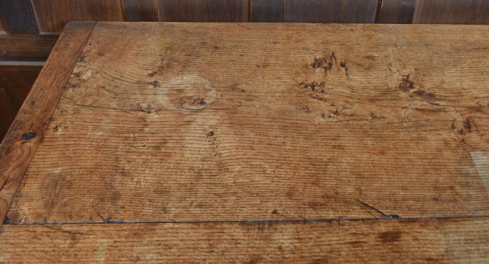 An 18th-century solid oak refectory table featuring a plank top and carved bulbous cup-and-cover turned legs resting on a stretcher base. View IX