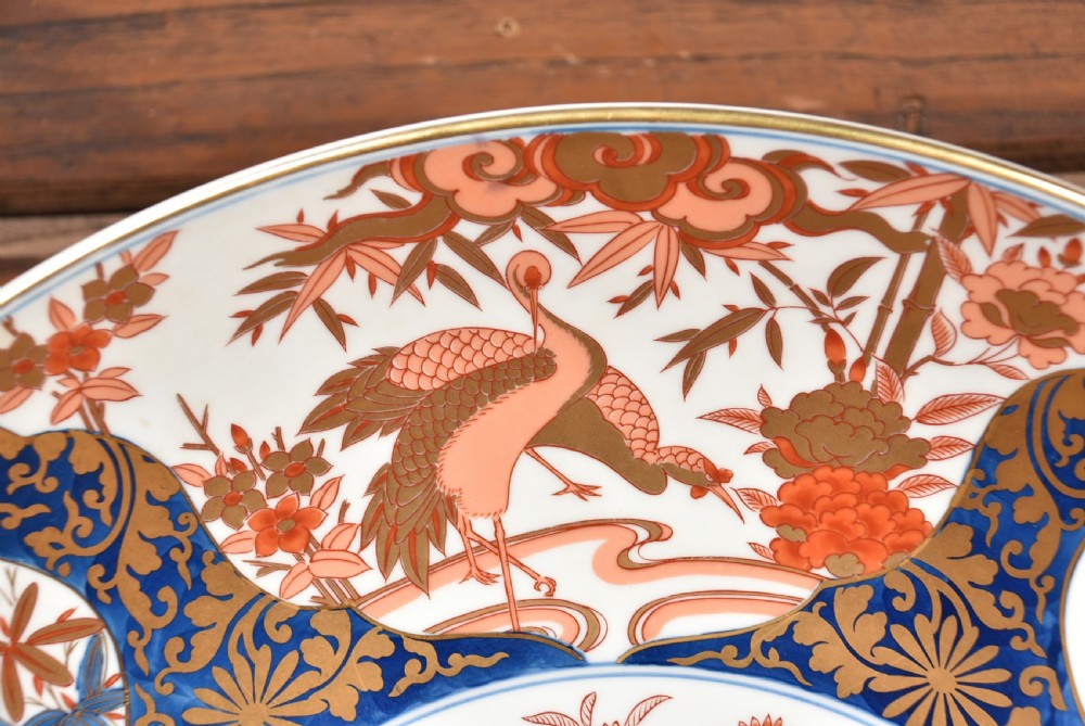 A large round Japanese Imari porcelain charger decorated with vibrant cobalt blue, terracotta red, and gilded floral and bird motifs. View III