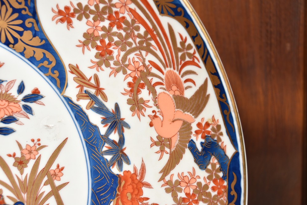 A large round Japanese Imari porcelain charger decorated with vibrant cobalt blue, terracotta red, and gilded floral and bird motifs. View V
