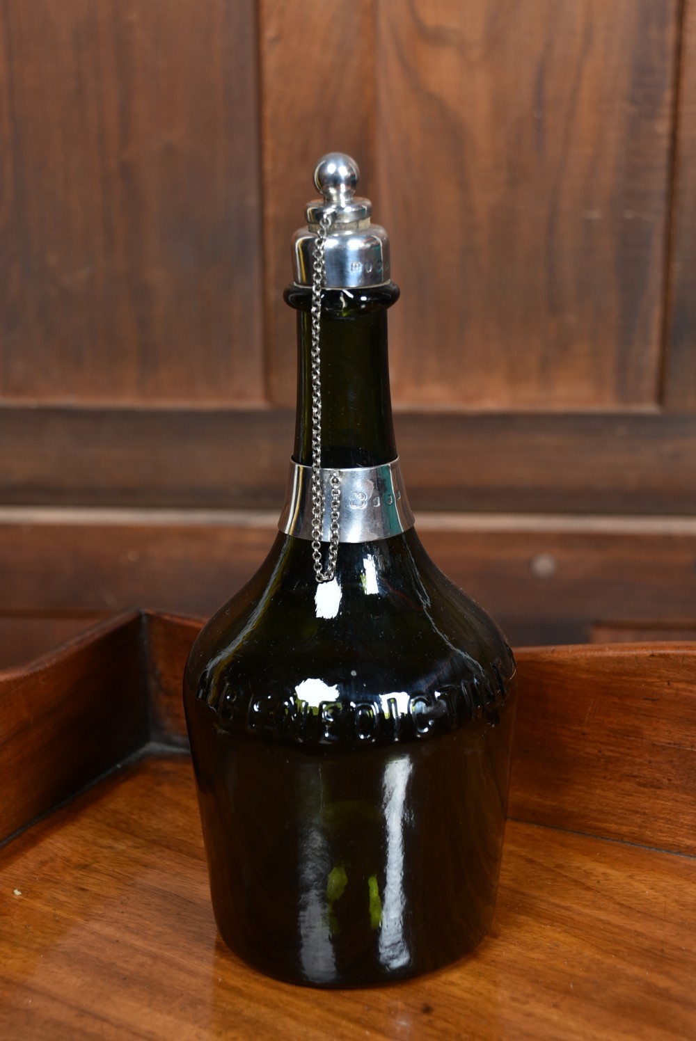 A dark green glass decanter featuring silver collar band, silver ball stopper, and a silver oval plaque engraved with WHISKEY. View IX