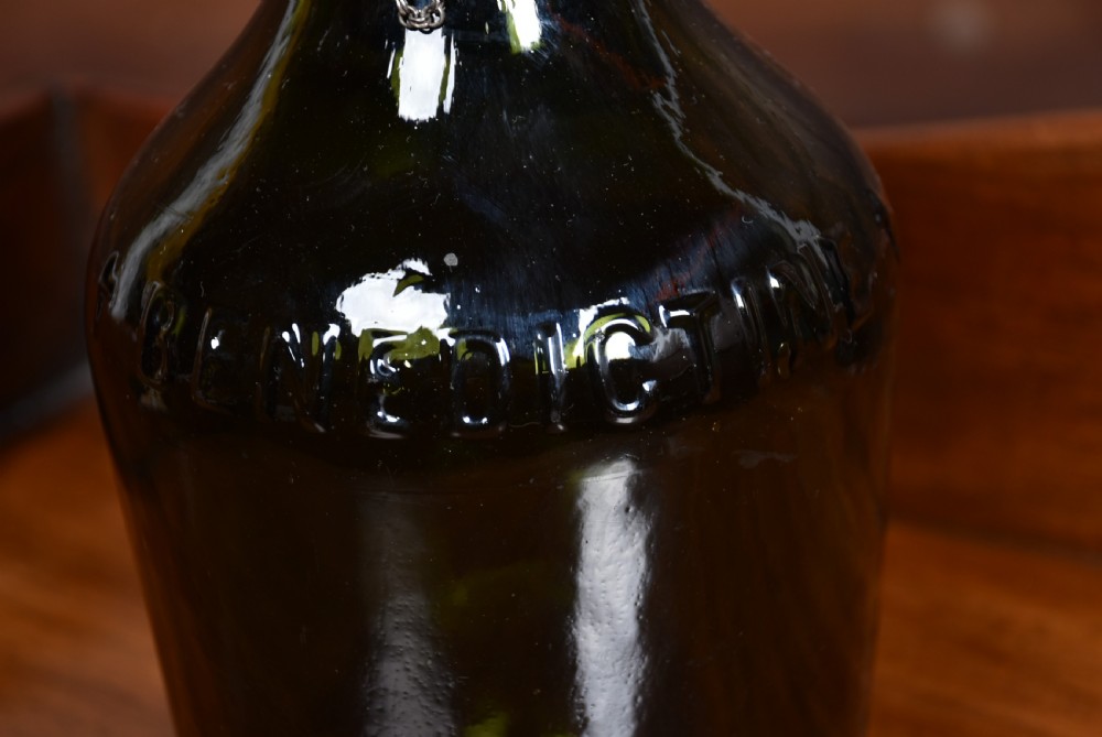 A dark green glass decanter featuring silver collar band, silver ball stopper, and a silver oval plaque engraved with WHISKEY. View XI