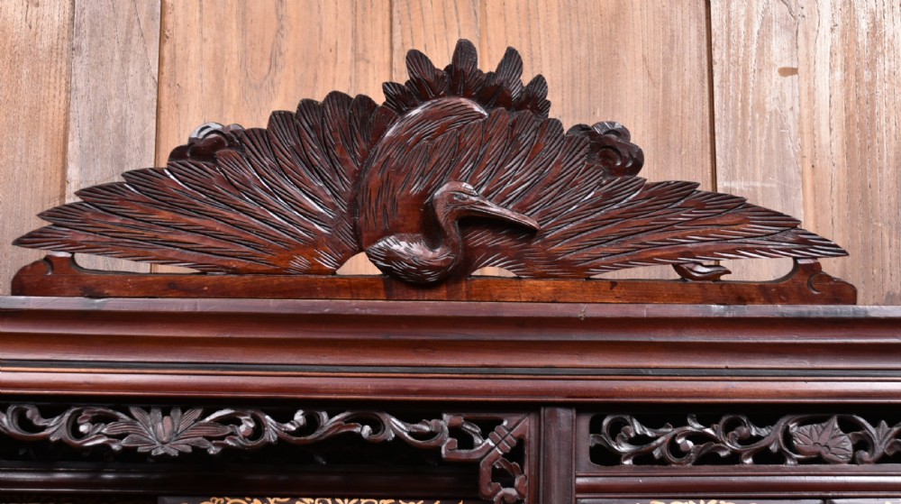 A tall Japanese Meiji period dark hardwood shodana cabinet featuring asymmetrical shelving, mother-of-pearl inlaid panels, bird carvings, and a cresting pediment. View VII