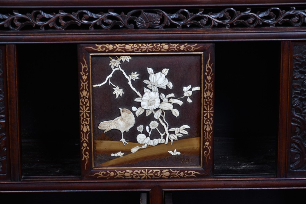 A tall Japanese Meiji period dark hardwood shodana cabinet featuring asymmetrical shelving, mother-of-pearl inlaid panels, bird carvings, and a cresting pediment. View VIII