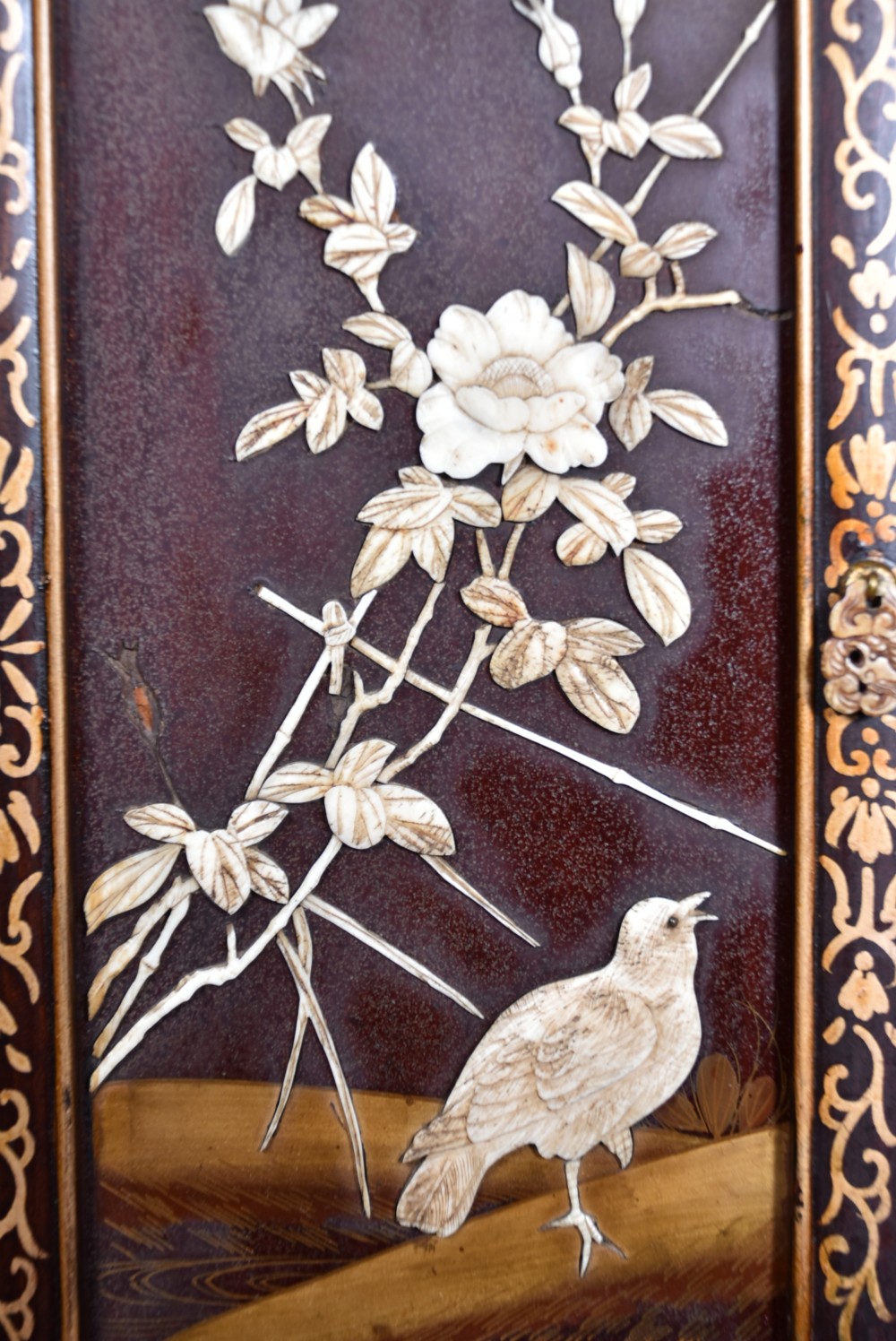 A tall Japanese Meiji period dark hardwood shodana cabinet featuring asymmetrical shelving, mother-of-pearl inlaid panels, bird carvings, and a cresting pediment. View XVI