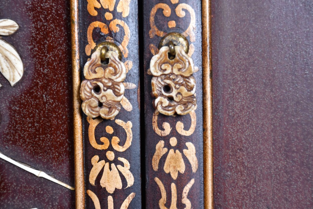 A tall Japanese Meiji period dark hardwood shodana cabinet featuring asymmetrical shelving, mother-of-pearl inlaid panels, bird carvings, and a cresting pediment. View XIX
