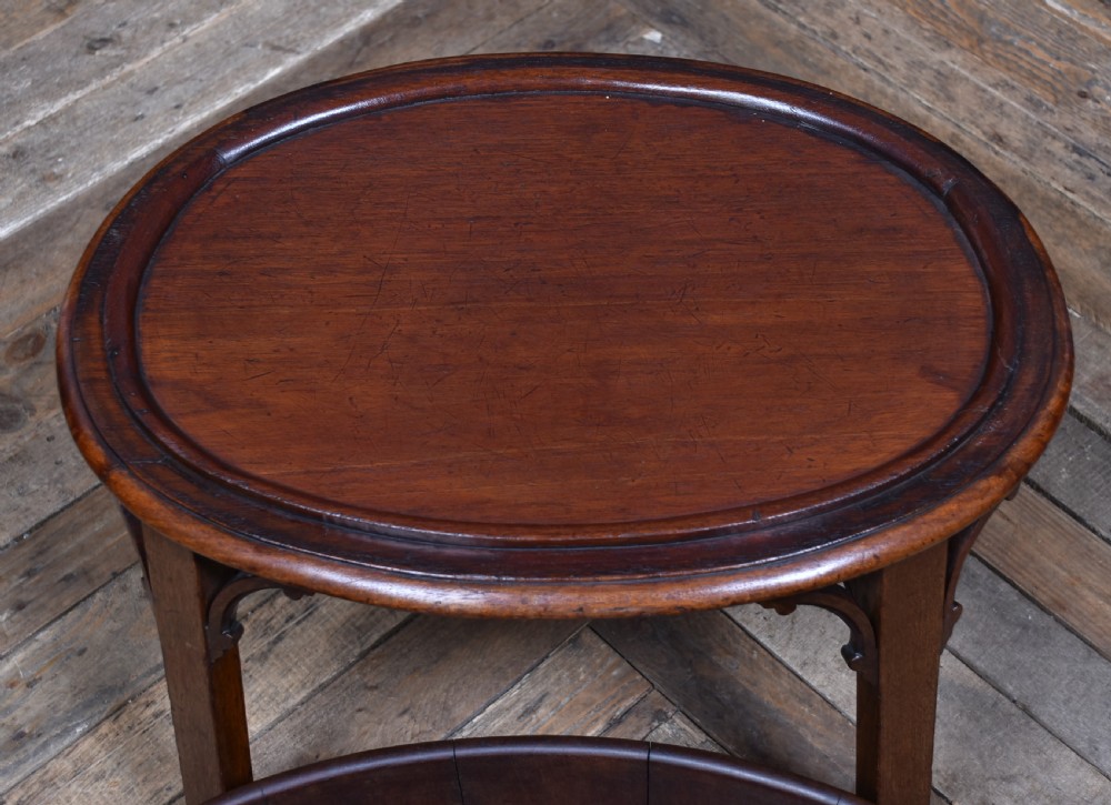 An oval George III mahogany wine cooler bound with two wide brass bands, featuring brass side handles and supported on a fitted wooden stand with four tapered legs. View IX