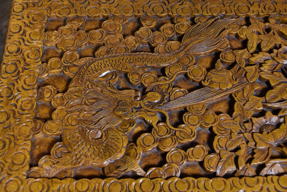 A deeply carved warm brown camphor wood storage chest featuring relief carvings of dragons and birds with a central brass clasp. View VI