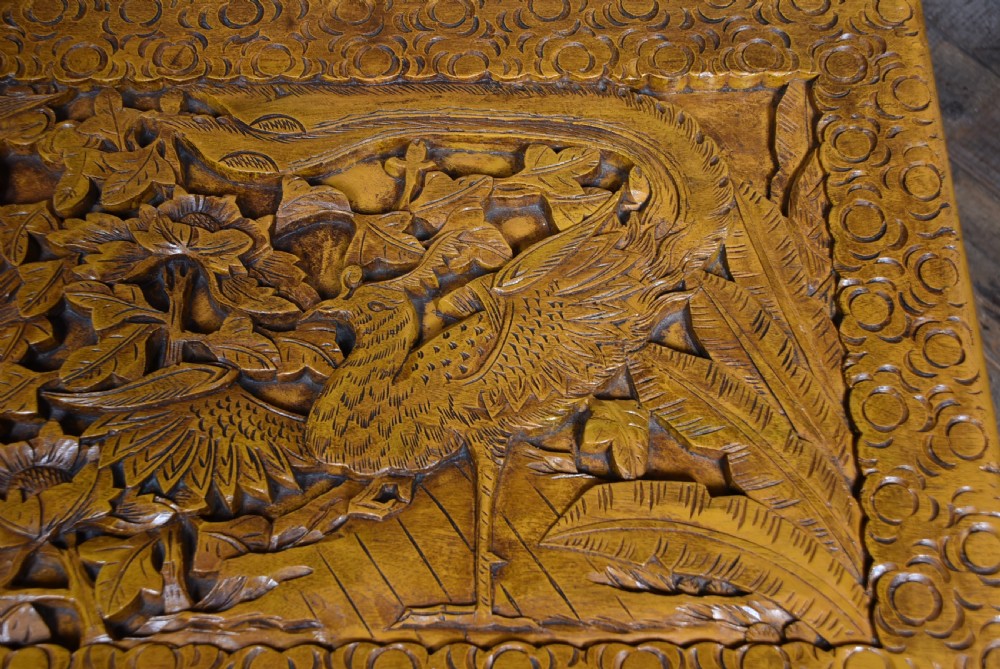 A deeply carved warm brown camphor wood storage chest featuring relief carvings of dragons and birds with a central brass clasp. View VIII
