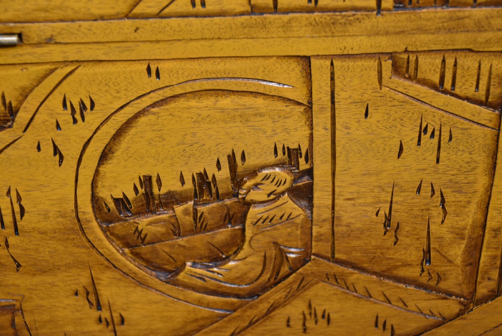 A deeply carved warm brown camphor wood storage chest featuring relief carvings of dragons and birds with a central brass clasp. View XIII