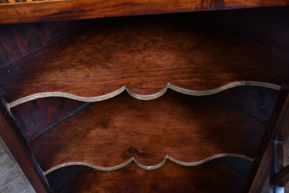 A Georgian mahogany wall-hanging corner cabinet featuring an astragal glazed door with geometric arches and shaped interior shelves. View IV