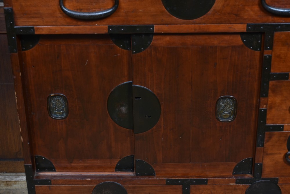 A Japanese keyaki wood merchant chest featuring multiple drawers, sliding central doors, and dark iron corner brackets and handles. View VII