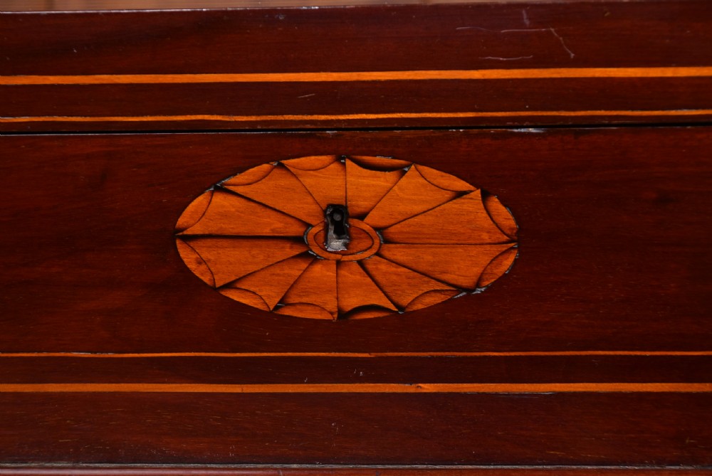 An antique Georgian mahogany writing desk with satinwood oval patera inlays, geometric stringing, two cupboard doors, and a hinged lid. View XVIII