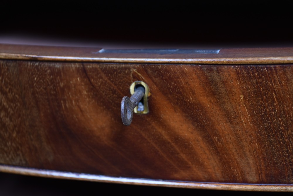 An Edwardian mahogany bow-front chest of drawers featuring six graduating drawers with brass ring handles and splayed bracket feet. View V