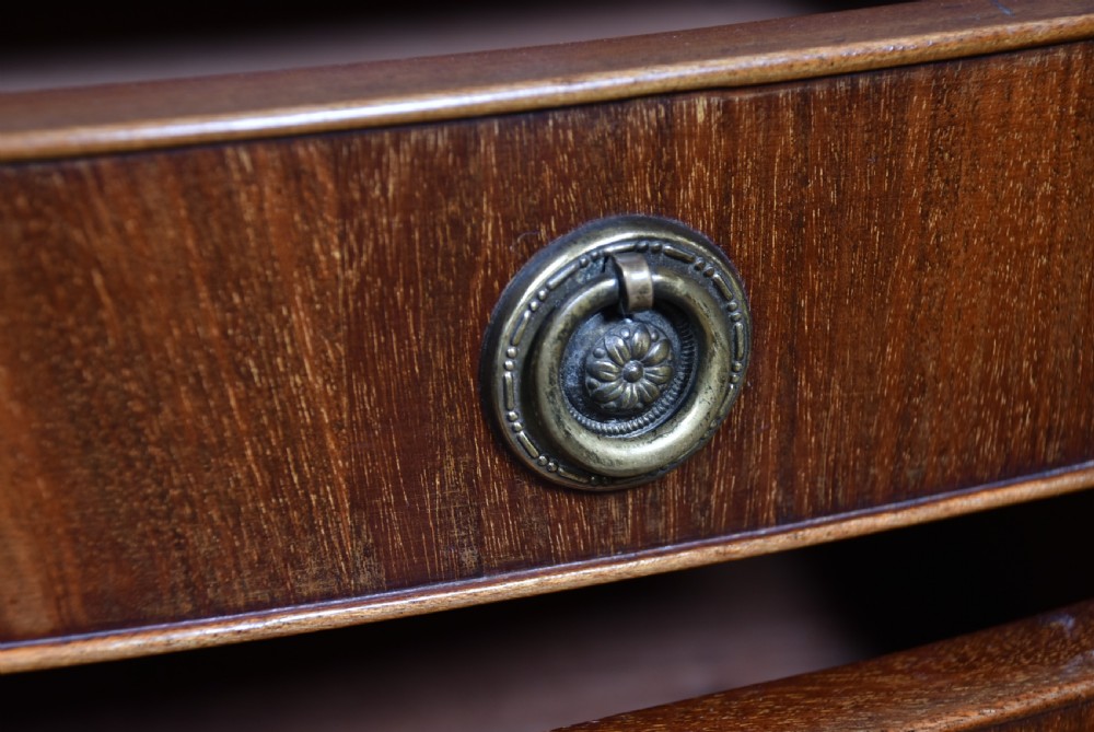 An Edwardian mahogany bow-front chest of drawers featuring six graduating drawers with brass ring handles and splayed bracket feet. View VI