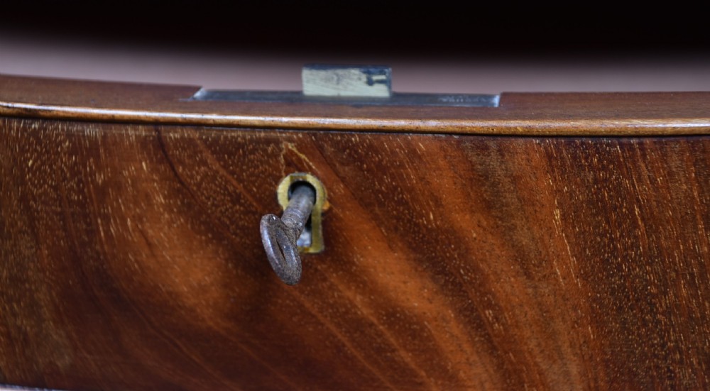 An Edwardian mahogany bow-front chest of drawers featuring six graduating drawers with brass ring handles and splayed bracket feet. View VII