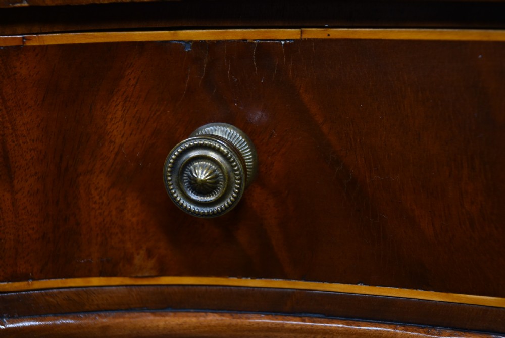 An Edwardian mahogany kidney-shaped desk featuring satinwood inlay, three frieze drawers with round brass handles, swept legs, and brass castors. View IX