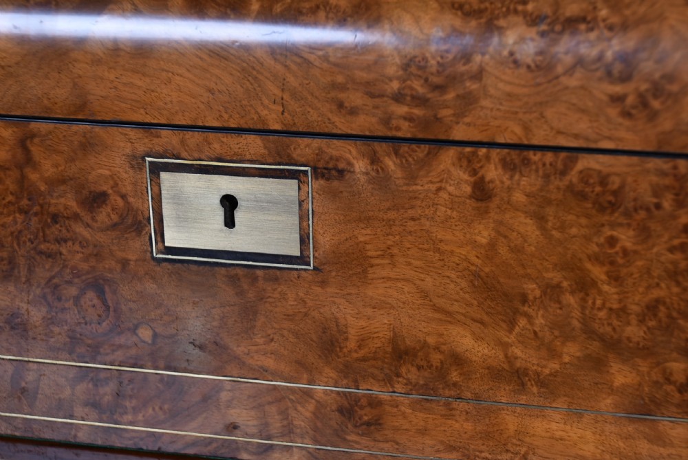 A Victorian burr walnut writing slope featuring brass stringing inlay, a central brass presentation plaque, and a brass keyhole escutcheon. View III