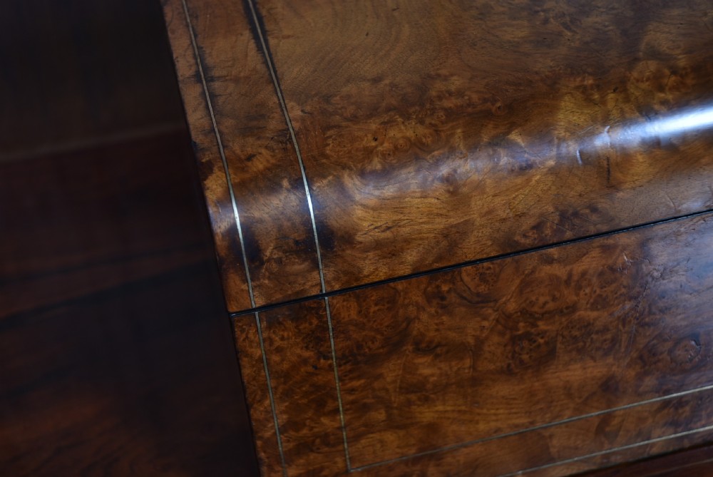 A Victorian burr walnut writing slope featuring brass stringing inlay, a central brass presentation plaque, and a brass keyhole escutcheon. View IV