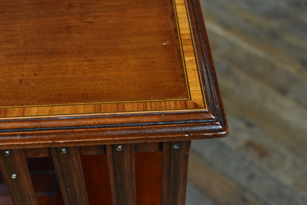 An Edwardian two-tier mahogany revolving bookcase with vertical slatted sides and a polished square top. View VII