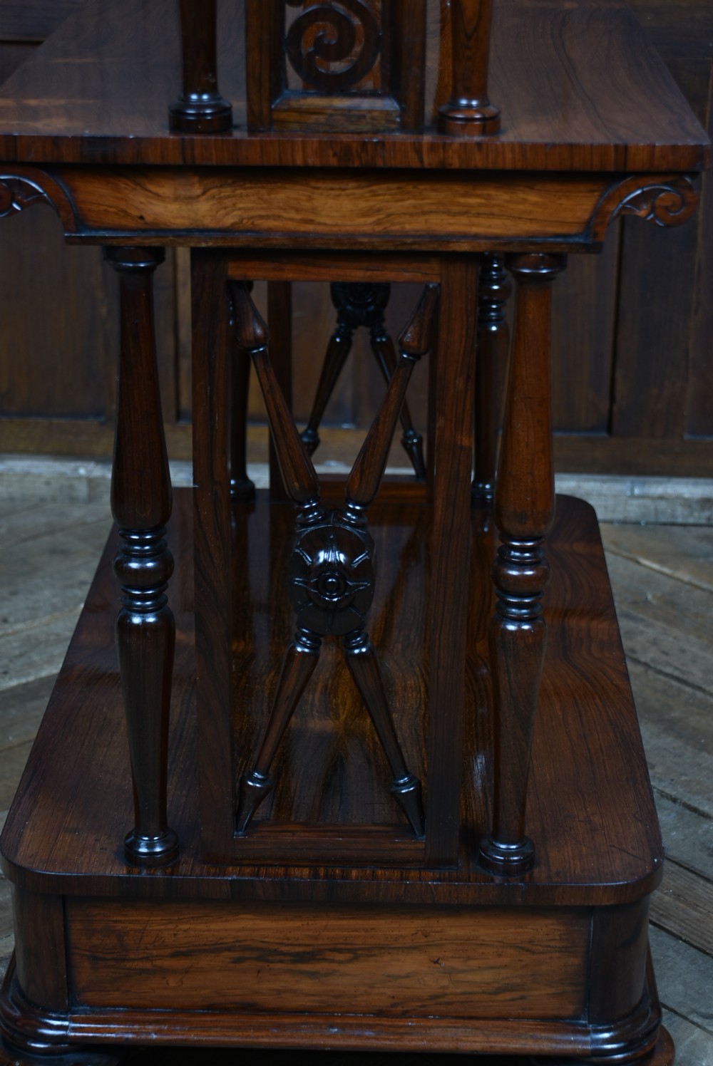 A three-tiered Victorian rosewood whatnot shelf featuring turned support columns, carved top details, and a single lower drawer with twin circular knobs. View XI
