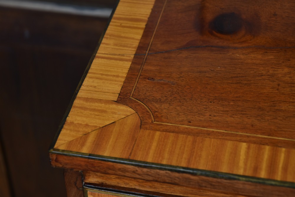 A Georgian mahogany chest of drawers featuring two short over two long drawers with intricate inlaid borders and splayed bracket feet. View IV