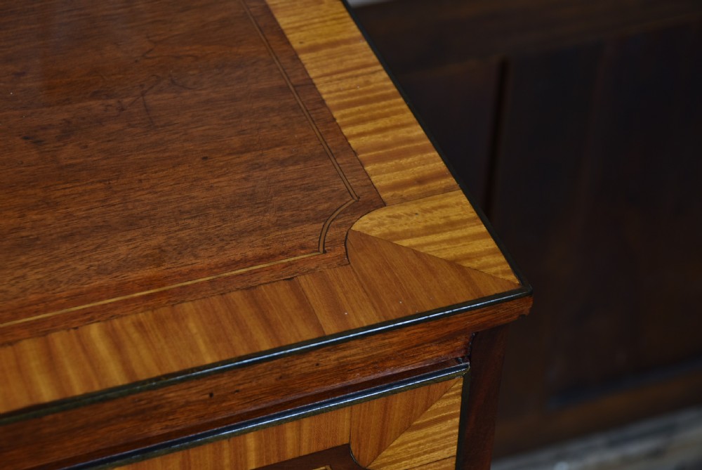 A Georgian mahogany chest of drawers featuring two short over two long drawers with intricate inlaid borders and splayed bracket feet. View V