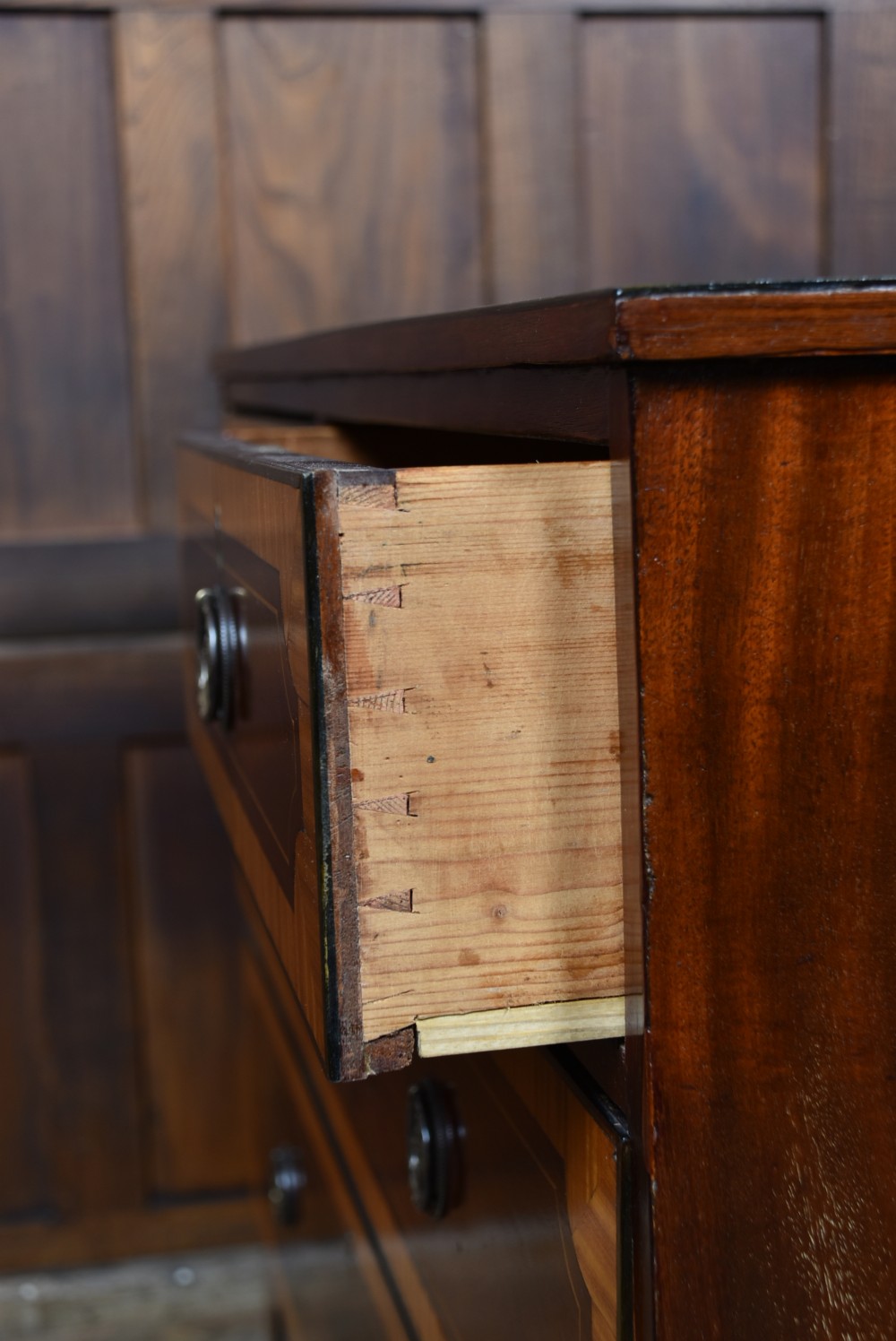A Georgian mahogany chest of drawers featuring two short over two long drawers with intricate inlaid borders and splayed bracket feet. View XV