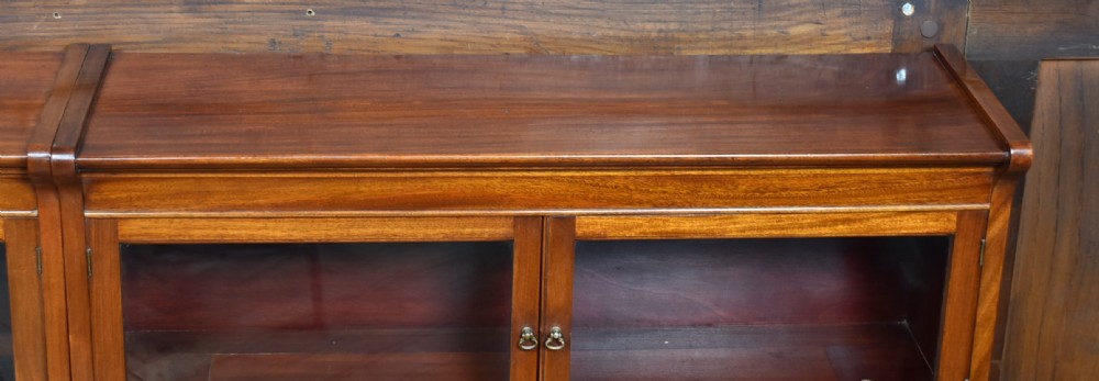 A pair of three-tier Edwardian mahogany sectional bookcases with glazed double doors and small brass handles placed side by side. View X