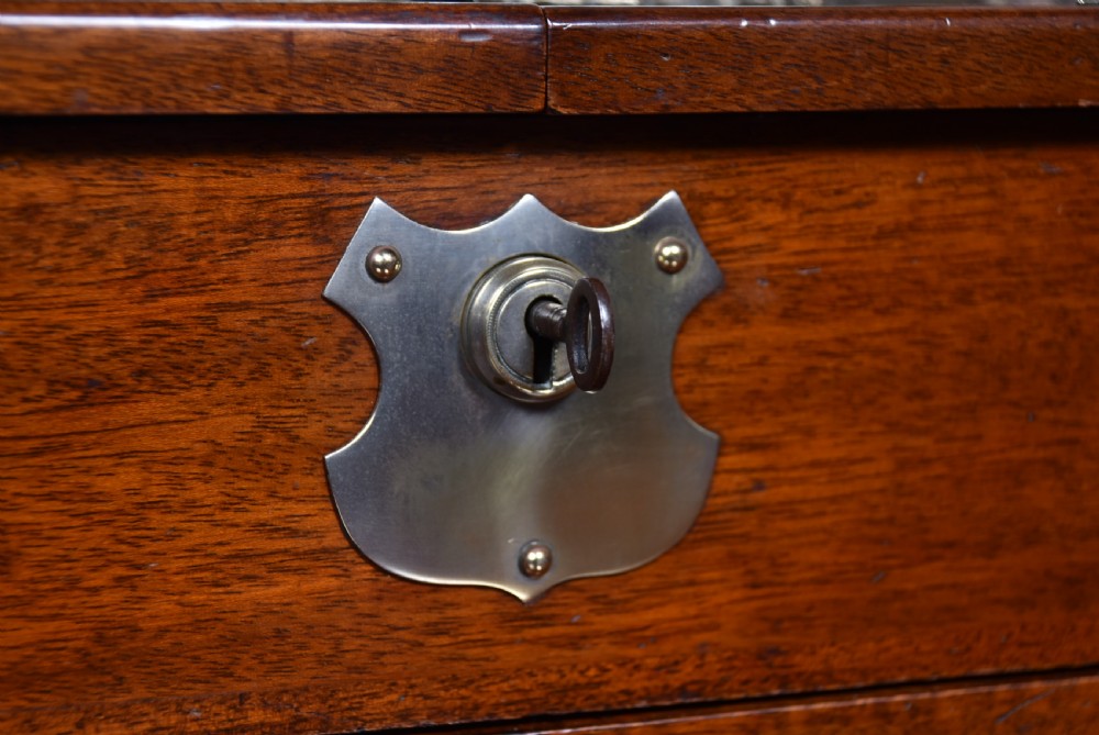 An Edwardian polished mahogany tantalus and games compendium featuring three cut crystal decanters and silver-toned brass strapwork mounts. View XVI