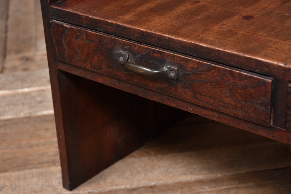 A low dark brown wooden Japanese calligraphy writing table featuring three drawers with iron handles and solid slab side supports. View IX