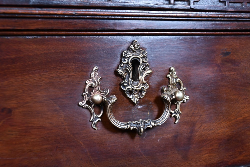A tall Georgian mahogany chest on chest featuring multiple graduated drawers with brass handles, blind fretwork frieze, and bracket feet. View III