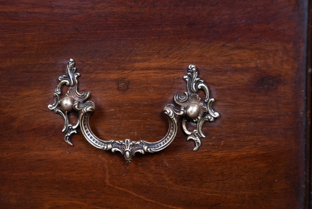 A tall Georgian mahogany chest on chest featuring multiple graduated drawers with brass handles, blind fretwork frieze, and bracket feet. View IV
