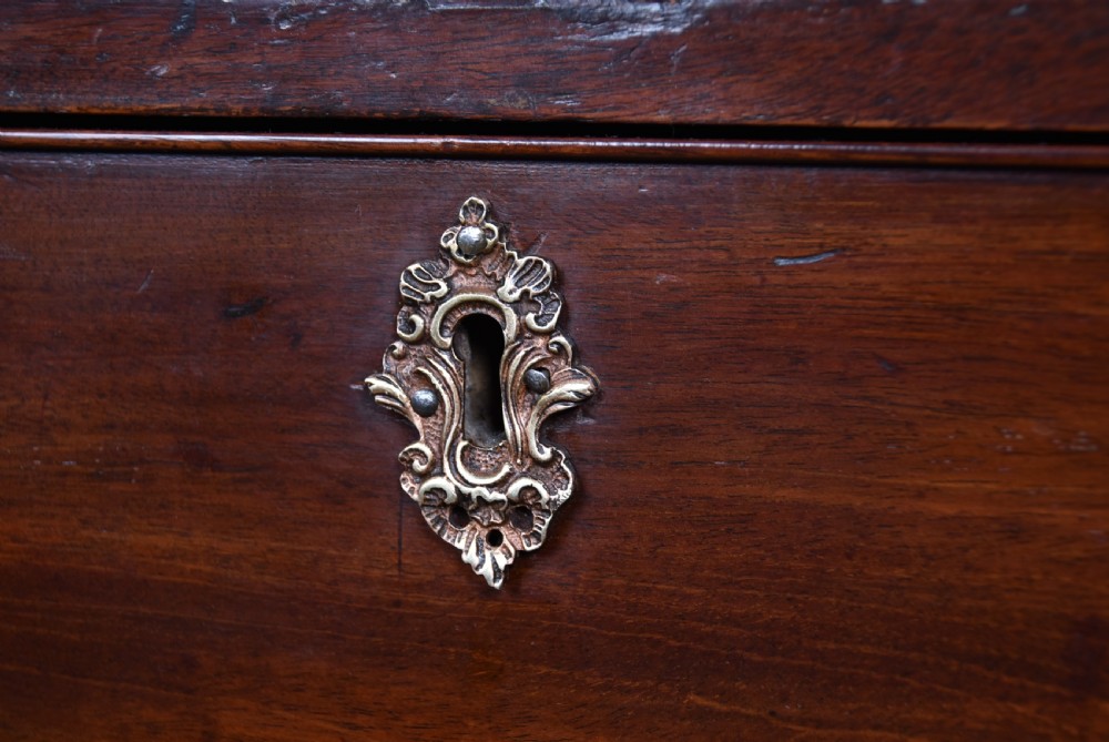 A tall Georgian mahogany chest on chest featuring multiple graduated drawers with brass handles, blind fretwork frieze, and bracket feet. View V