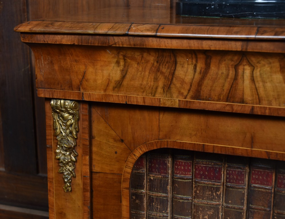 A low Victorian burr walnut breakfront bookcase featuring three arched glass doors, floral marquetry inlay, and gilt bronze mounts. View IV