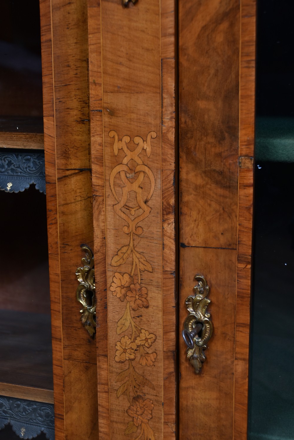 A low Victorian burr walnut breakfront bookcase featuring three arched glass doors, floral marquetry inlay, and gilt bronze mounts. View VI