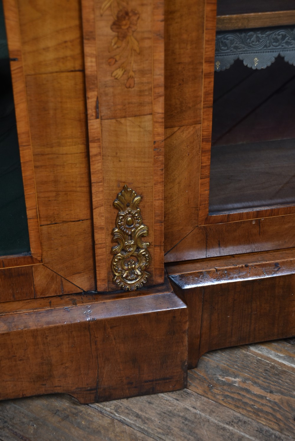 A low Victorian burr walnut breakfront bookcase featuring three arched glass doors, floral marquetry inlay, and gilt bronze mounts. View VII