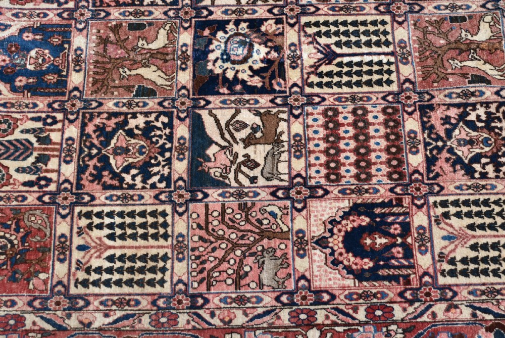 A hand-knotted Persian wool rug featuring a grid panel design with tree and floral motifs enclosed by a detailed terracotta border. View II