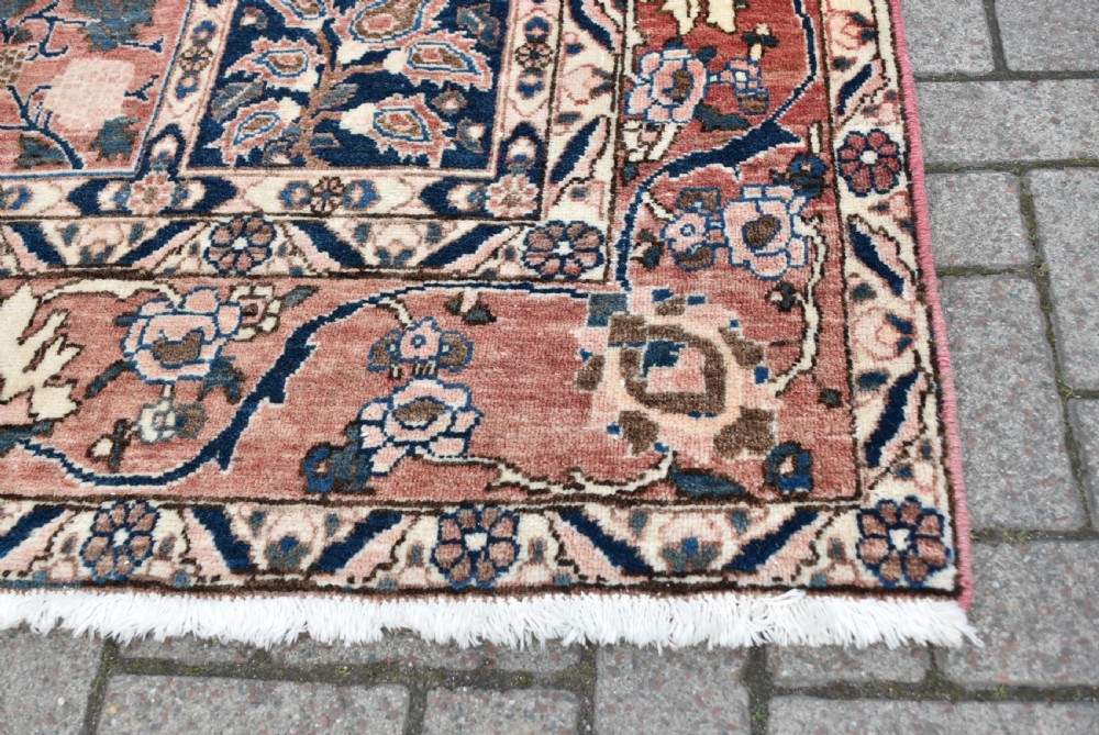 A hand-knotted Persian wool rug featuring a grid panel design with tree and floral motifs enclosed by a detailed terracotta border. View VII