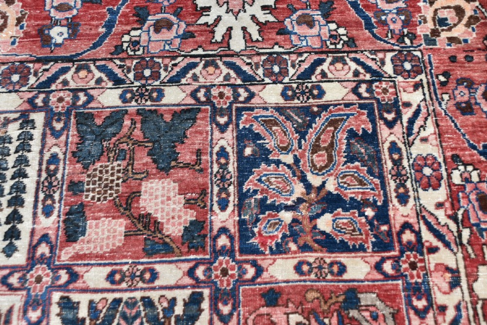 A hand-knotted Persian wool rug featuring a grid panel design with tree and floral motifs enclosed by a detailed terracotta border. View XI